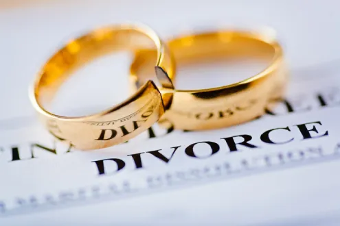 Two broken golden wedding rings divorce decree document